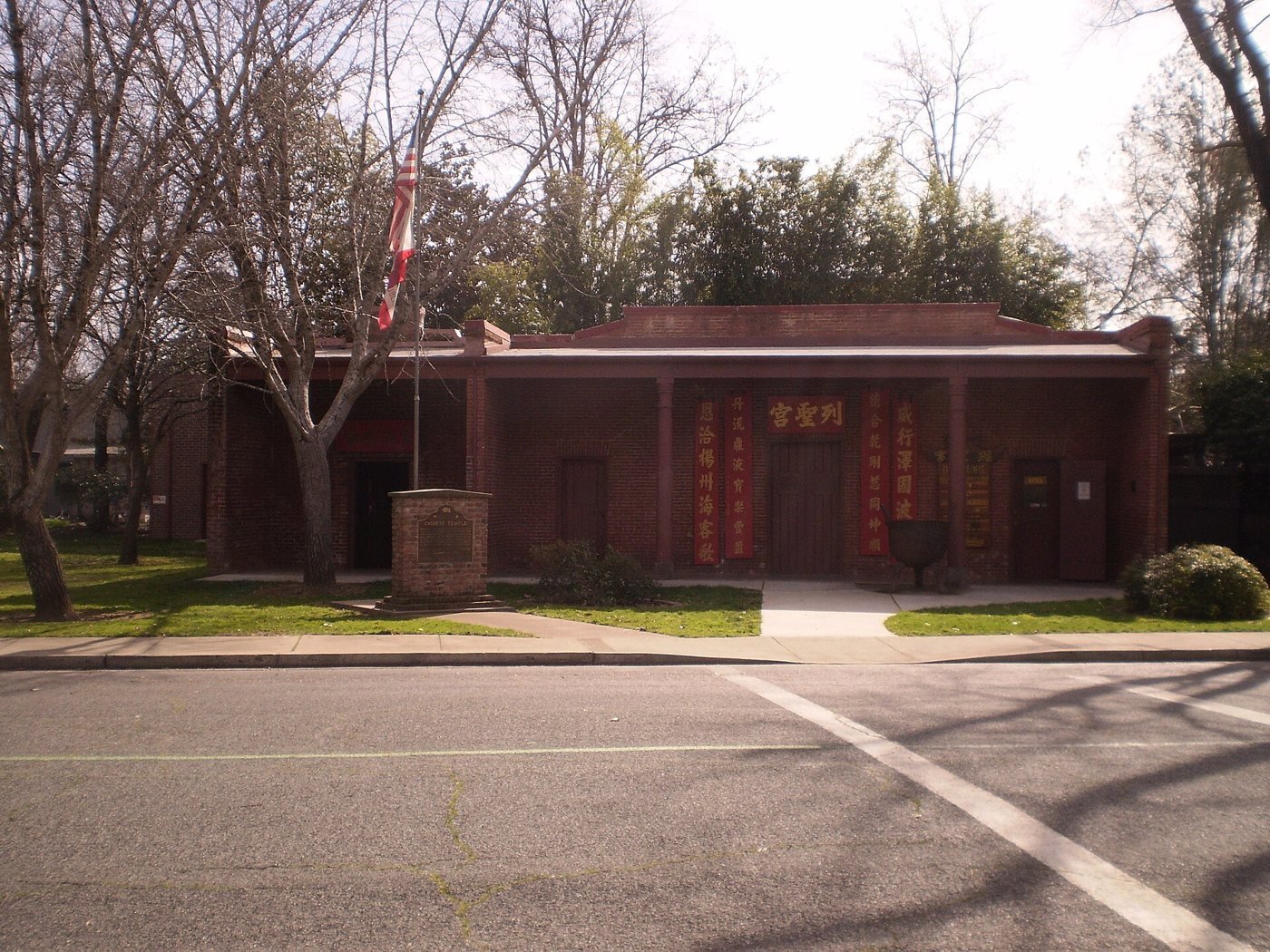 Front of the Oroville Chinese Temple on Broderick Street, with red doors and its landmark marker