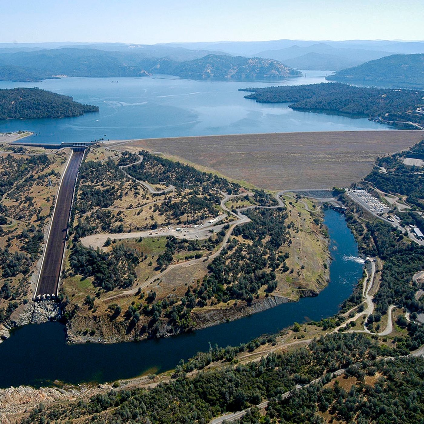 Aerial view of Oroville Dam with Lake Oroville behind it and the Feather River below